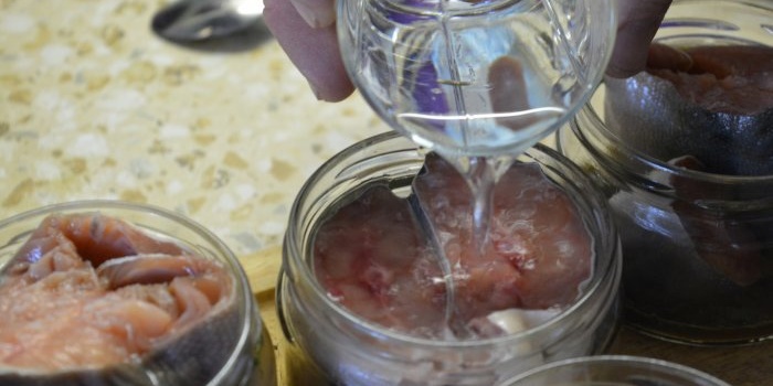 Homemade canning of pink salmon in a pressure cooker